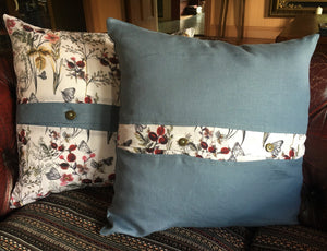 Denim blue linen cushions with a vibrant berry trim and berry print cushions with a contrasting blue linen button trim. 