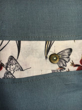 Load image into Gallery viewer, Denim blue linen cushions with a vibrant berry trim and berry print cushions with a contrasting blue linen button trim. 