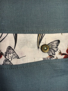 Denim blue linen cushions with a vibrant berry trim and berry print cushions with a contrasting blue linen button trim. 