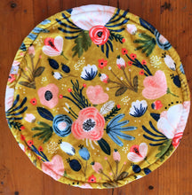 Load image into Gallery viewer, a round cat mat made with 3 layers of minky. Featuring a floral cottage garden design with a bright mustad background and pink and blue flowers