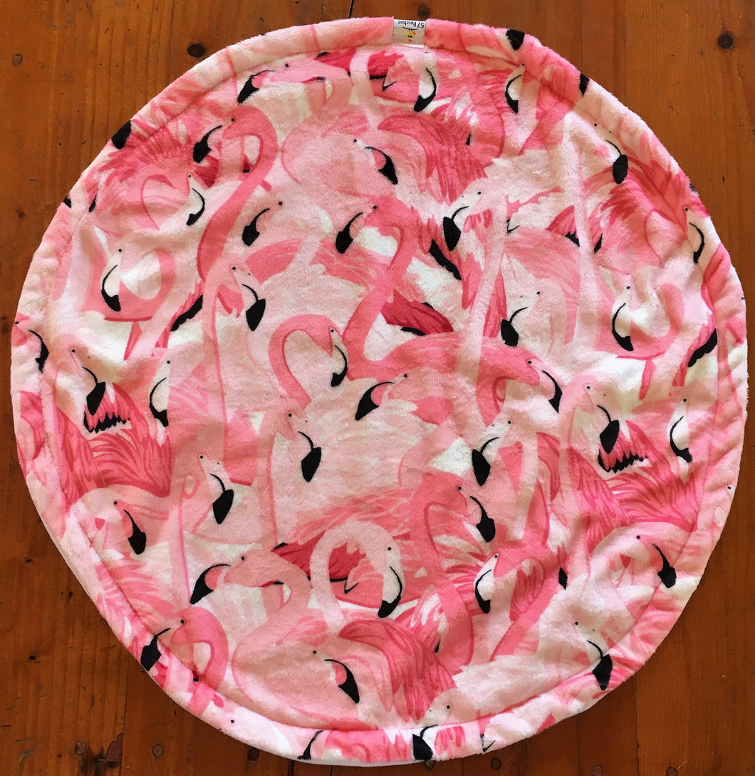 a round cat mat made with 3 layers of minky. Featuring a busy flamingo design in various shades of pink and withy black beaks