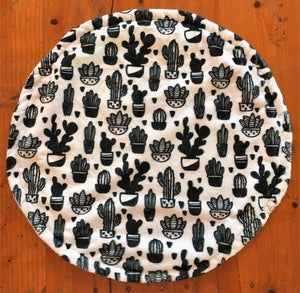 a round cat mat made with 3 layers of minky. Featuring various black and white cactuses in pots on a white background, A monochrome design