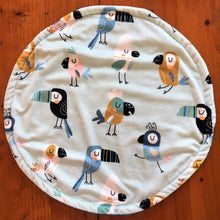 Load image into Gallery viewer, a round cat mat made with 3 layers of minky. Featuring toucan and parrot like birds in tan, black, blue and pink on a pale blue background