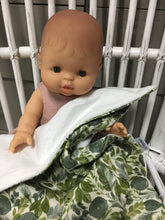 Load image into Gallery viewer, Dolls minky blanket cotton front synthetic minky back green leafy foliage print doll sitting on cane chair with blanket covering lap minky showing
