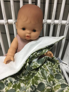 Dolls minky blanket cotton front synthetic minky back green leafy foliage print doll sitting on cane chair with blanket covering lap minky showing