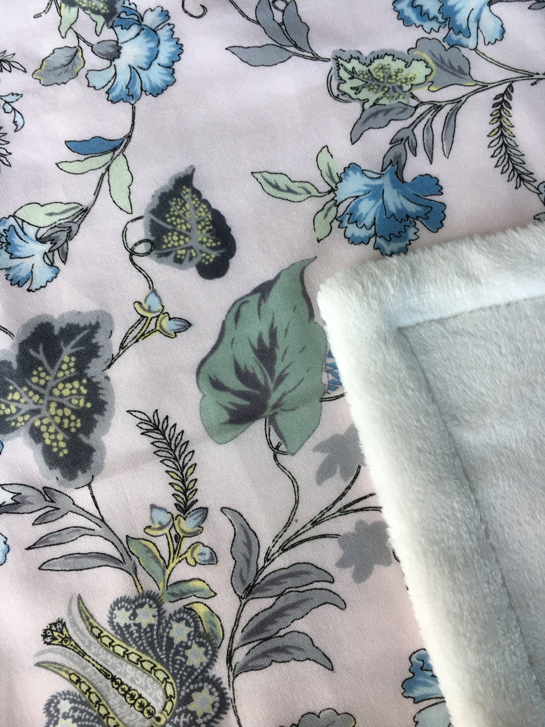 Tropical garden print minky blanket cotton front synthetic lining closeup shows printed cotton and folded corner to reveal minky lining